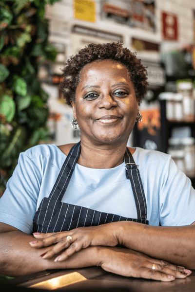 A woman in an apron smiling at the camera.