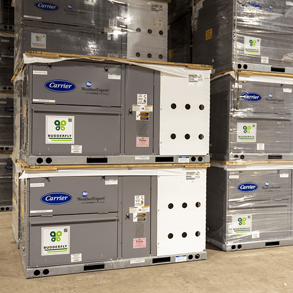 A group of Carrier air conditioners stacked on top of each other in a warehouse.