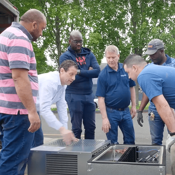 A group of men standing around a unit.