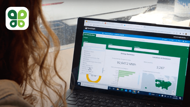 Woman looking at a laptop with Budderfly's energy management software on the screen.