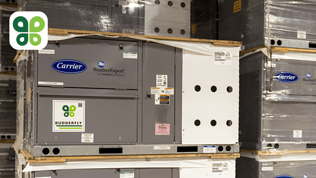 A group of Carrier air conditioners stacked on top of each other in a warehouse.