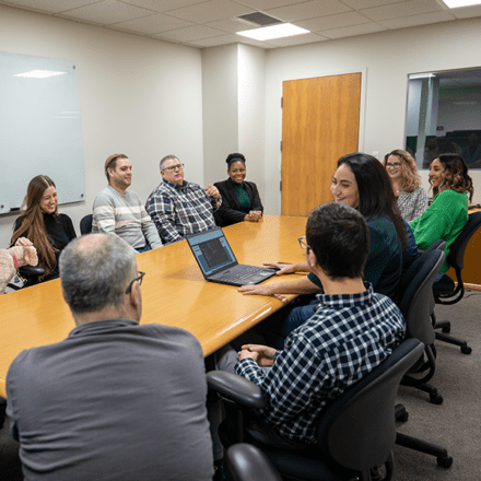 A group of people sitting and talking in a conference room.