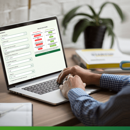 Person in checkered shirt typing on a laptop displaying Budderfly's Energy Saving Calculator.
